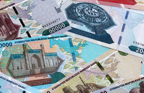 Uzbekistani som money banknotes pile on table. Uzbekistan bills of UZS currency close up