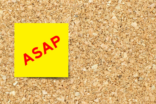Yellow note paper with word ASAP (Abbreviation of as soon as possible) on cork board background with copy space