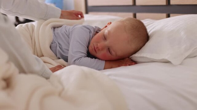 Mother gently trying to wake up her toddler baby boy. Little boy wake up for a wile turns and asleep again. 4K