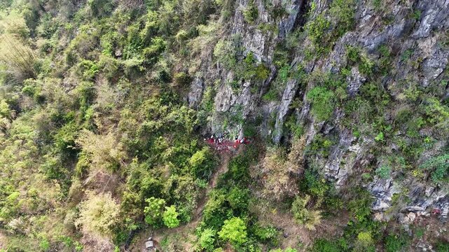 Aerial Shot of Hardcore Qingming Ancestor Worship in Guangxi, People Carrying Offerings Up Steep Mountain