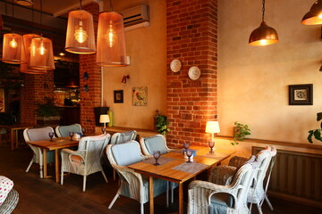 Comfortable cafe space featuring wicker furniture and dim lighting © diczman