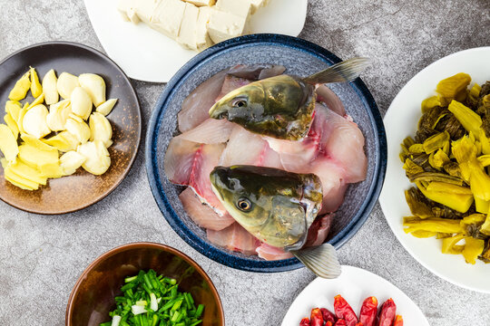 The fish head and raw fish slices of the grass carp are placed in a porcelain bowl.