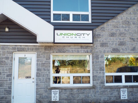 Nepean, Ontario, Canada &ndash; July 27, 2025: The "Carlington Booch" storefront features a horizontal sign for a kombucha brewery, gray stone walls, large windows, and white doors at 81 Auriga Dr #4.