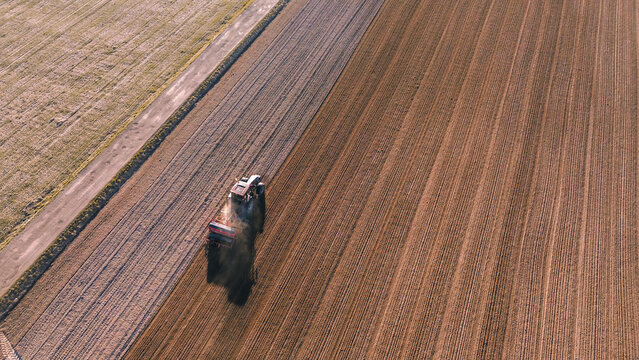Drone shot of farming tractor on arable land