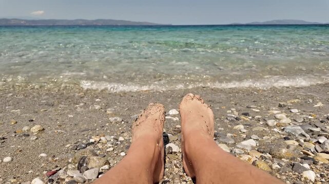Man sunbathing on a rocky sea ocean beach.