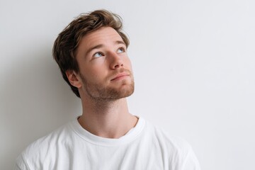 Obraz premium Isolated head-and-shoulders portrait of a thoughtful man on white background, future-focused mood