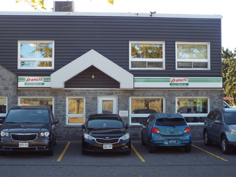 Nepean, Ontario, Canada &ndash; July 27, 2025: The "Francis HVAC Services Ltd." storefront features white signs with green stripes, gray stone walls, and several parked cars outside at 81 Auriga Dr Unit #1.