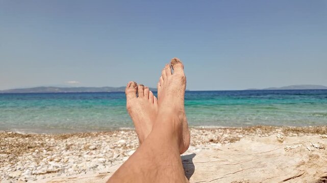 Man sunbathing on a rocky sea ocean beach.
