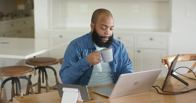 Man sipping mug while scanning laptop, spotting surprise, leaning and typing on tablet for business