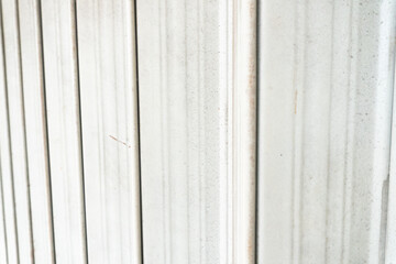 Obraz premium White vertical corrugated iron panels, commonly used for interior wall design. These iron panels feature a vertical striped pattern, creating a textured backdrop.