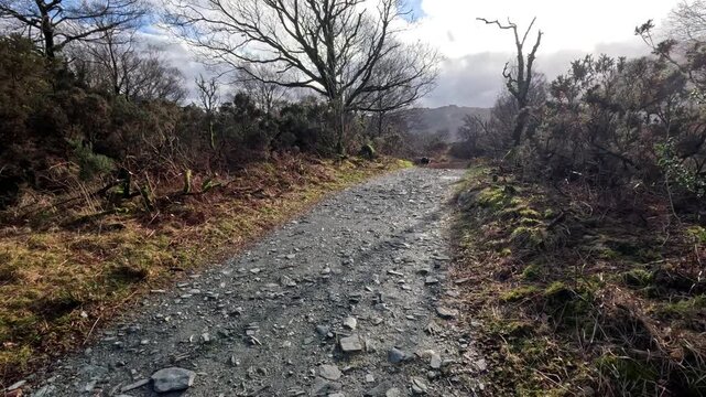 Point of view walking along a rocky pathway in the Lake District with wide mountain landscape views UK