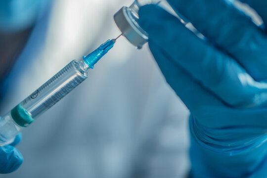 A gloved hand draws liquid from a vial into a syringe, symbolizing vaccination and healthcare safety. This photo emphasizes immunization, prevention, and medical innovation