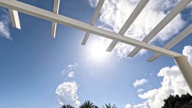 POV looking up at blue sky from a sunny Spanish balcony.