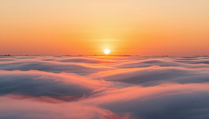 Fototapeta premium a vibrant sunrise over rolling clouds. The clouds appear soft, and the sky transitions from orange to pink, highlighting the beauty of the landscape.