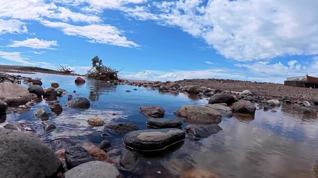 Low point of view shot of a rugged volcanic coastline, showcasing the dramatic terrain and untamed natural landscape of Gran Canaria.