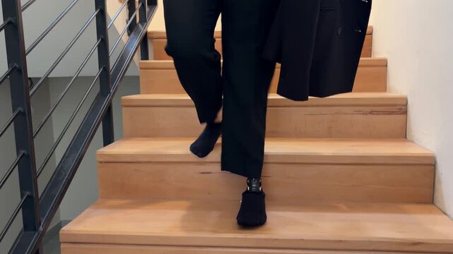 Amputee person with prosthetic leg walking down stairs