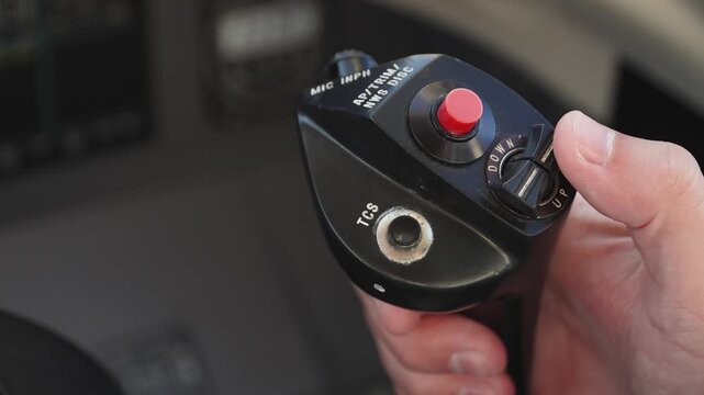 Pilot uses engine control lever in business jet. Unrecognizable man moves sliders of throttle levers of engines. Red emergency button activating optimal parameters for landing or takeoff.