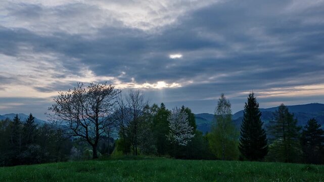 Evening clouds time-lapse over green landscape and mountain range
