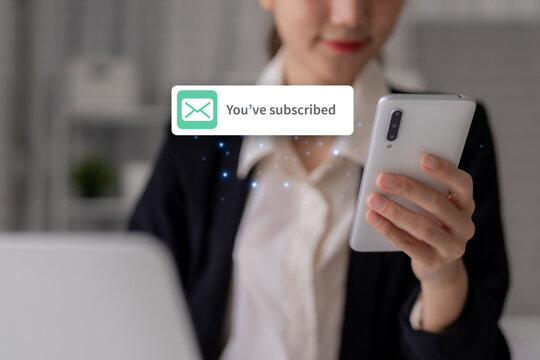 Businesswoman receives subscription confirmation on mobile phone for online newsletter showing successful email marketing engagement technology subscription notification
