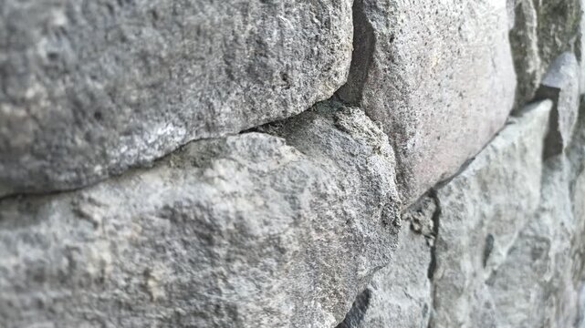 Close-up of a rough stone wall texture with natural rock formations.