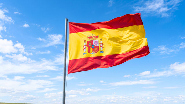flag of spain waving against the blue sky