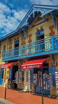 Soulac sur Mer, France - June 08, 2025. The colorful vintage bookstore Librairie de Corinne in the background of the blue sky with white clouds in sunny day.