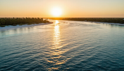 Obraz premium a calm waterway reflecting the sunset. The warm sunlight illuminates the river, surrounded by trees and a sandy shore.