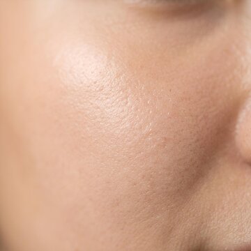 Close-up view of a person's glowing facial skin with natural light reflection