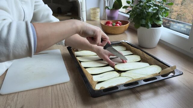 Cutting cross pattern on eggplant slices to release moisture Preparing vegetables before baking