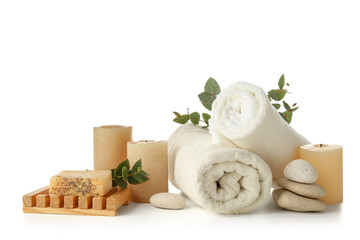 Spa stones with candles, towels, soap bar and eucalyptus branches on white background © Pixel-Shot