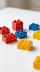 Naklejka premium A collection of colorful plastic building blocks in red, blue, and yellow, arranged on a white surface, perfect for kids and children to play and learn