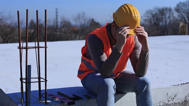 Construction worker having a depressed period, headache, issues on a construction site outdoors.