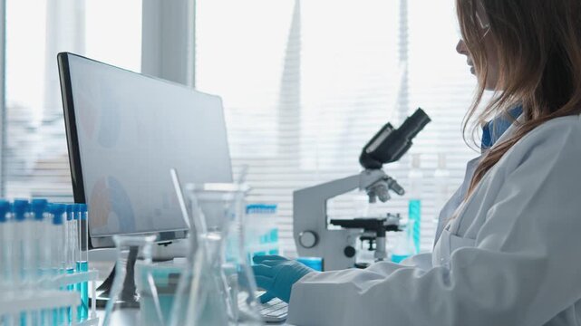 A skilled scientist analyzes complex data on a powerful computer while using lab equipment, highlighting ongoing innovative research and advancements in science and technology that drive progress