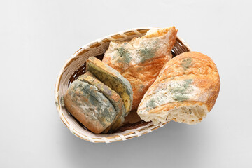 Wicker basket with moldy bread on blue background © Pixel-Shot