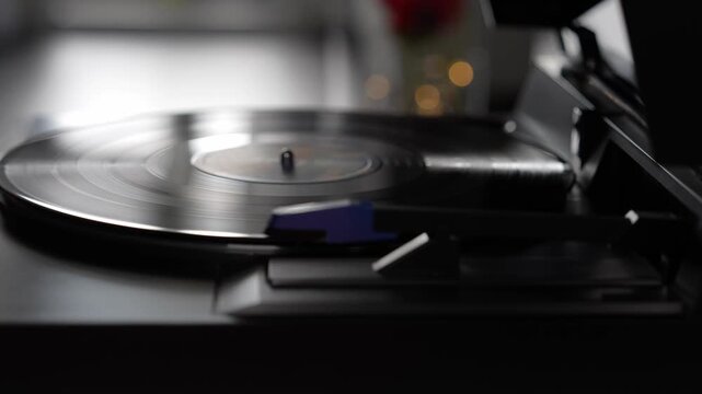 Hand touching vinyl record on turntable, analog music lifestyle concept