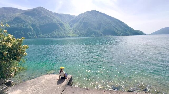 Woman Sitting on Pier by Calm Lake, Peaceful Nature Scene for Wellness, Meditation, Travel and Lifestyle Background with Copy Space