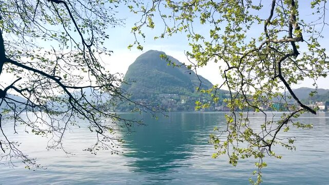 Lake Lugano View Through Lush Park Vegetation with Monte San Salvatore Mountain, Scenic Nature Landscape for Travel and Relaxing Background