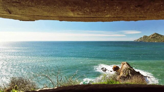 View from an abandoned military battery on the Cartagena coast of Portman, on a day with waves crashing against the coastal rocks