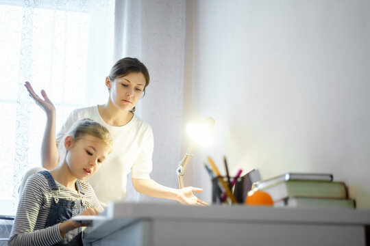 Mother and daughter doing homework together, styding and learning concept, doing tasks for school