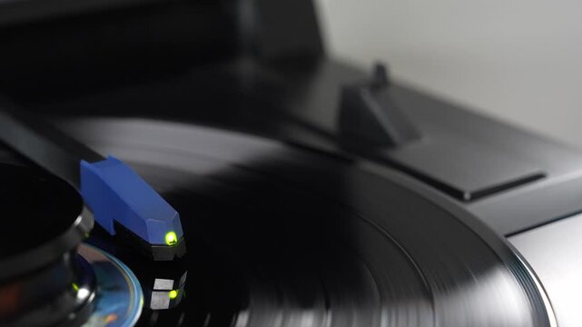 Stylus needle playing spinning vinyl record on turntable, analog music concept   