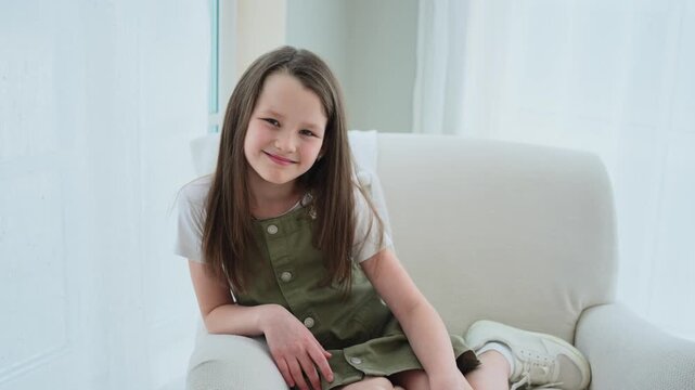 Happy girl at home. Smiling cute little brown haired Caucasian girl looking at camera. Portrait of happy female child at home. Smiling face of 10 year old girl looking at camera