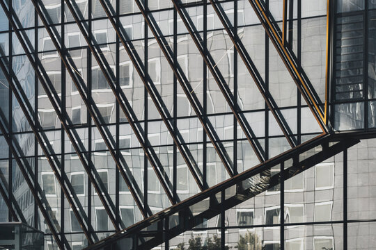 Geometry pattern within modern grid of glass windows and exposed structure on architecture building facade suggesting industrial order and design