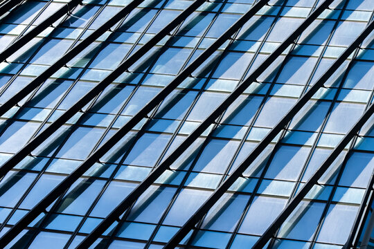 Modern symmetry pattern emerges from diagonal lines on glass windows of architecture building facade evoking motion structure and urban innovation
