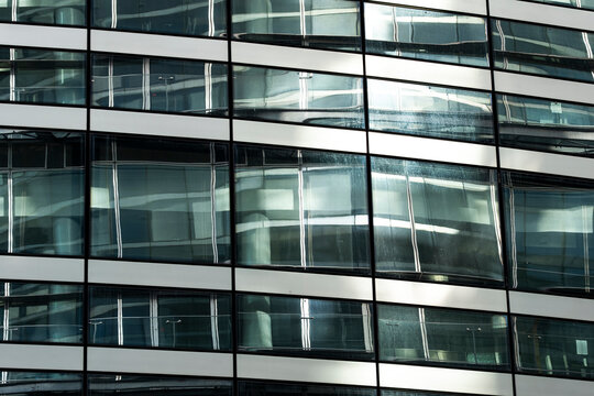 Symmetry pattern in windows grid of modern office building facade and glass architecture creating structured corporate mood for urban workspace imagery