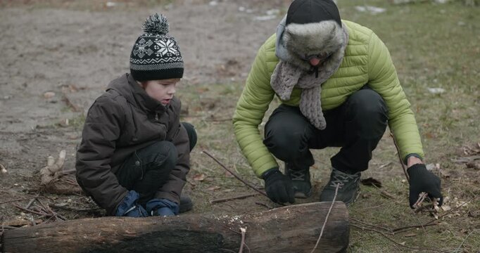 Men with kid cut branches in backyard and stockpile firewood in shed for winter. 4K 10-bit