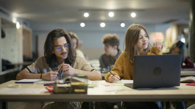 Young students diligently work on their assignments and engage in focused learning activities. They are absorbed in their studies, utilizing books and technology in a modern educational environment.