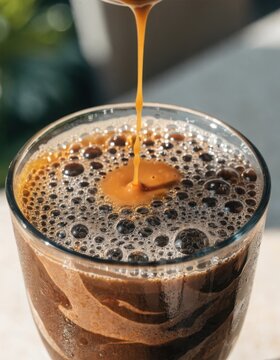 Caramel drizzled over a layered blueberry and cream dessert in a paper cup