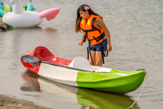 Young woman enjoying kayaking at lagoon during summer vacation