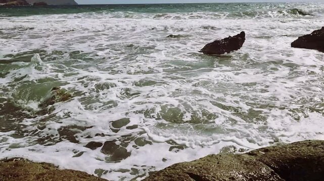 Sea with waves in a coastal area with rocks and cliffs of volcanic formation on the coast of Almeria, Cabo de Gata