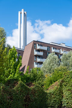 Urban Hamburg skyline with chimney and industry building in Germany set above greenery during autumn creating a contrasting landscape view